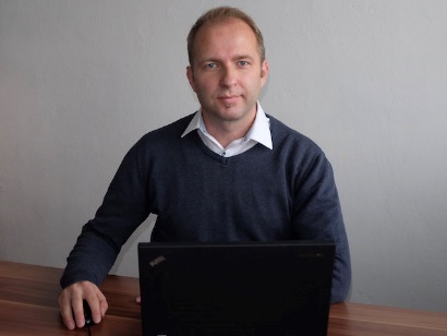 A person standing in front of a computer Description automatically generated